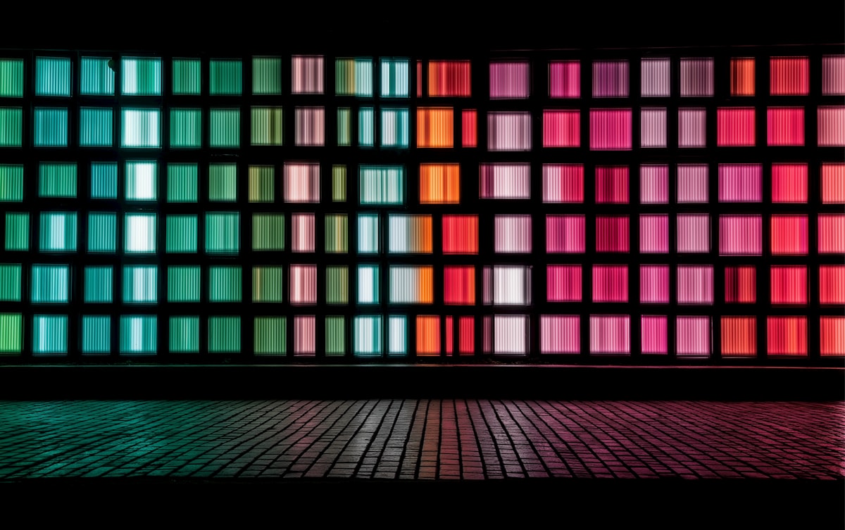 Grid of colorful lights on a dark wall.